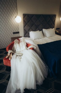 Gelinlik ve aksesuarlar yatağın üzerinde.