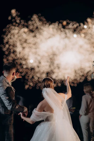 一对新婚夫妇在城市上空观看夜空中的烟火 — 图库照片