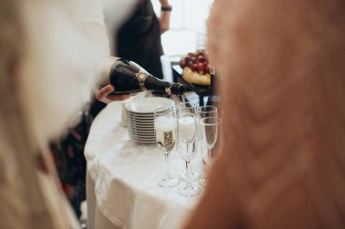 Yemek servisi, garson bardaklara alkol doldurur.