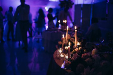 Parti, masa takımı, bardaklar diskodaki dansçıların arka planına karşı.