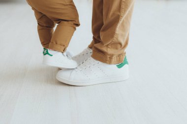 Baba oğluyla oynuyor, bacaklar kapalı.