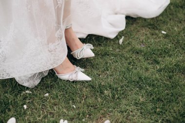 Gelin bacakları zarif ayakkabılarla yakın plan.