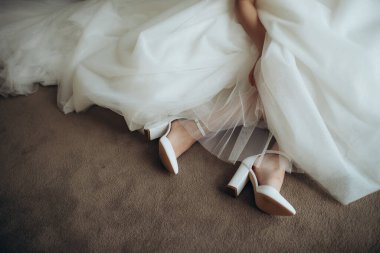 Gelin bacakları zarif ayakkabılarla yakın plan.