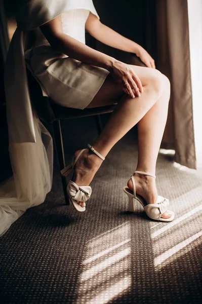 Gelin bacakları zarif ayakkabılarla yakın plan.