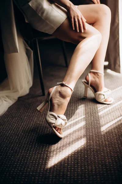 Gelin bacakları zarif ayakkabılarla yakın plan.