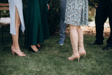 Bekarlığa veda partisinde zarif gece elbiseleri giyen nedimelerin bacakları.