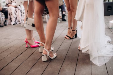 Bekarlığa veda partisinde zarif gece elbiseleri giyen nedimelerin bacakları.