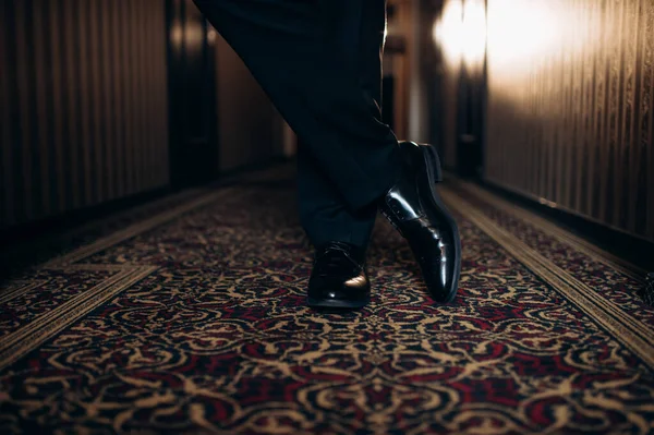 Otelde siyah takım elbiseli bir damadın bacakları.