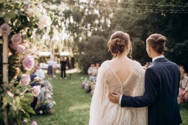 Damat gelini belinden kucaklıyor.