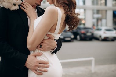 Damat gelini belinden kucaklıyor.