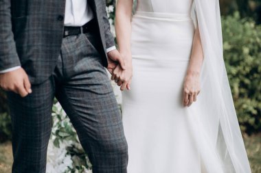 Yeni evliler el ele tutuşuyorlar.