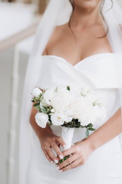 Gelin nazikçe düğün buketini tutuyor