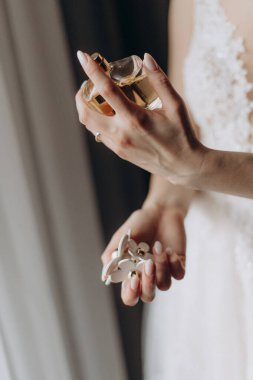 Gelin gelinlik içinde bir şişe parfüm taşıyor.