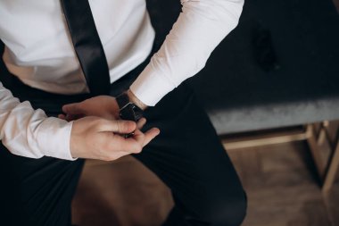 Takım elbiseli işadamı kol saatine bakıyor.