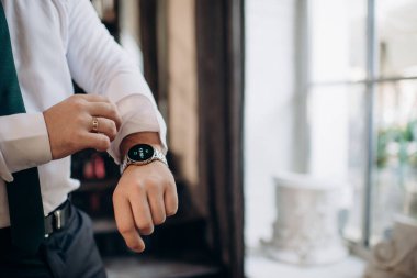 Takım elbiseli işadamı kol saatine bakıyor.