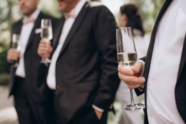 Bir şölende elinde alkol bardakları olan insanlar.