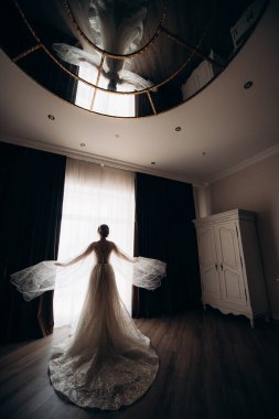 Gelinlik giymiş gelin pencerenin önünde.