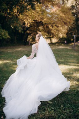 Gelinlik giymiş gelin doğada koşuyor.