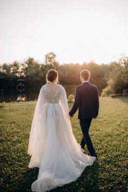 Gelin ve damat parkta yürüyor.