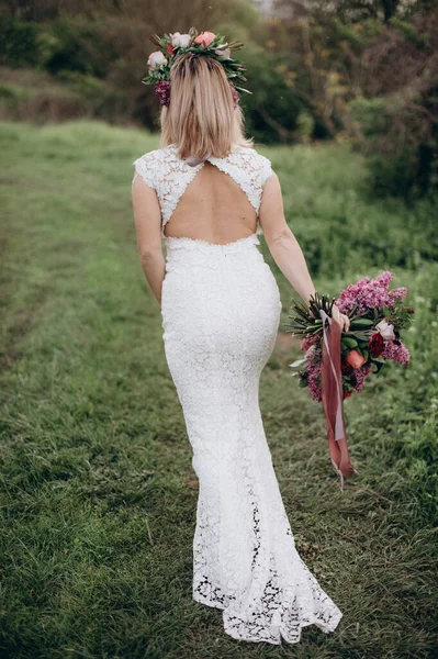 Gelinlik giymiş gelin doğada koşuyor.