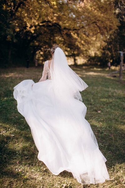 bride in a wedding dress runs in nature