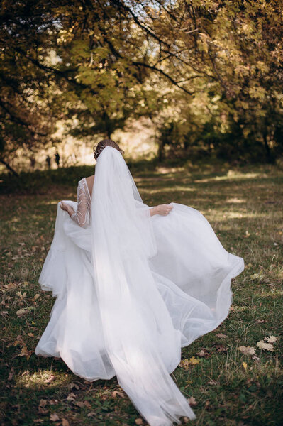 Bride in a wedding dress runs in nature