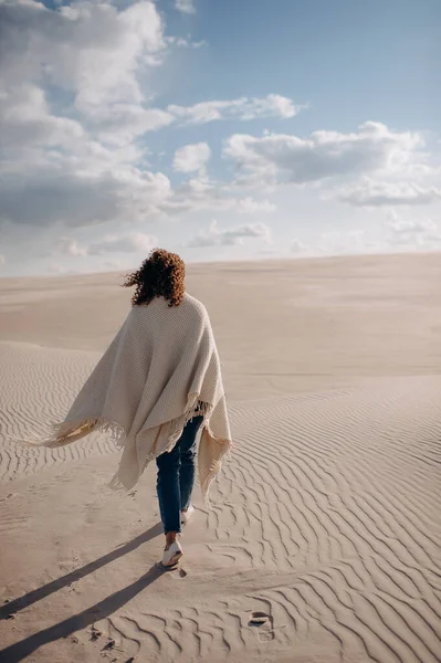 Kum tepelerinde yürüyen biri.