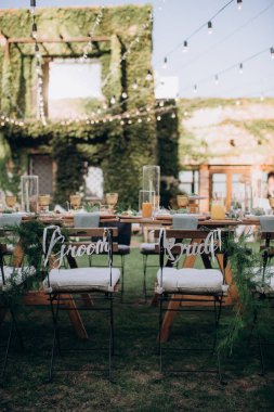 Yeni evlilerin sandalyeleri üzerinde yazı olan şenlik masasında.