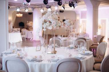 Yuvarlak servis masasında büyük bir çiçek aranjmanı var.