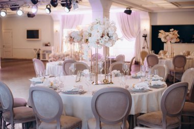 Yuvarlak servis masasında büyük bir çiçek aranjmanı var.