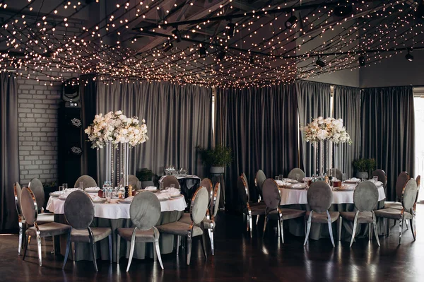 Yuvarlak servis masasında büyük bir çiçek aranjmanı var.