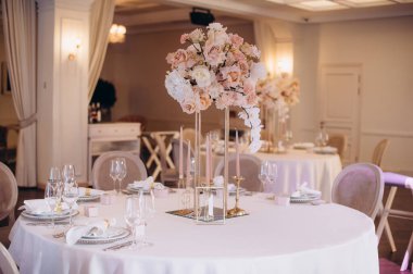 Düğün ziyafeti masasının dekorunda zarif bir çiçek aranjmanı.