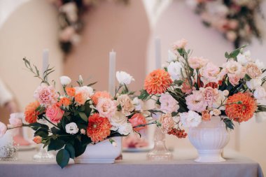 Düğün masasında zarif bir çiçek aranjmanı var.