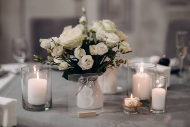 Düğün masasında zarif bir çiçek aranjmanı var.