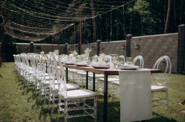 Verandada dikdörtgen düğün festivali sehpası, doğada bahçe.