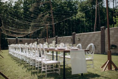 Verandada dikdörtgen düğün festivali sehpası, doğada bahçe.