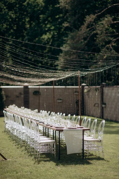 Verandada dikdörtgen düğün festivali sehpası, doğada bahçe.
