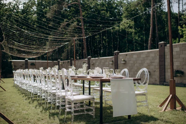 Verandada dikdörtgen düğün festivali sehpası, doğada bahçe.