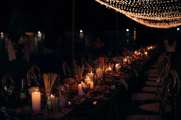 Şenlik masasında gece mumlar ve çelenkler