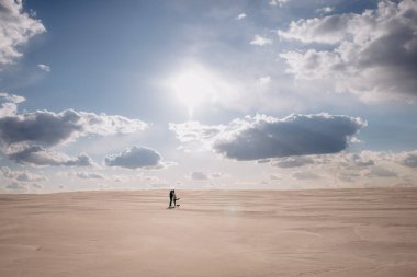 Kumsalda yürüyen çift.