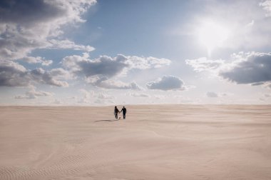 Kumsalda yürüyen çift.