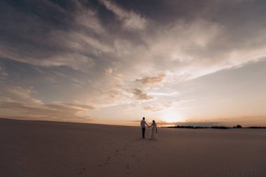 Kumsalda yürüyen çift.