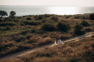 Tepelerin arasında tarlada yürüyen çift.