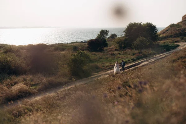 Tepelerin arasında tarlada yürüyen çift.