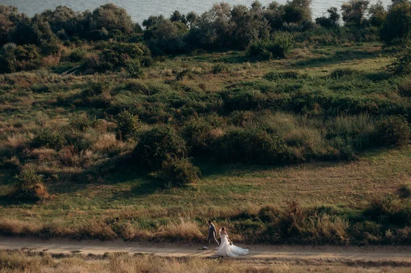 Tepelerin arasında tarlada yürüyen çift.