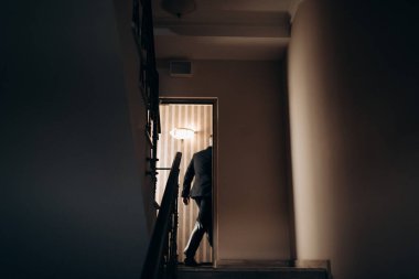 silhouette of a young man entering the door