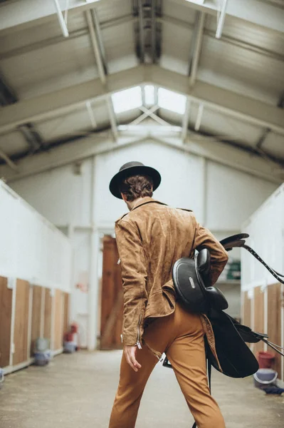 Young Male Cowboy Walks Stable Saddle His Hands — Stok Foto