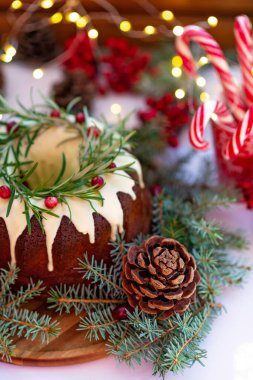 Noel karamelli pasta, beyaz çikolata, kızılcık, biberiye ve yeni yıl süslemeleri ile süslenmiş. Şenlikli pişmiş yiyecekler. Yumuşak seçici odaklanma. Dikey