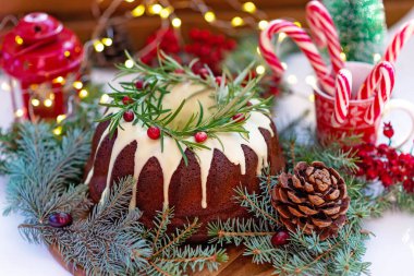 Noel karamelli pasta, beyaz çikolata, kızılcık, biberiye ve yeni yıl süslemeleri ile süslenmiş. Şenlikli pişmiş yiyecekler. Yumuşak seçici odaklanma. Yatay