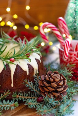 Noel karamelli pasta, beyaz çikolata, kızılcık, biberiye ve yeni yıl süslemeleri ile süslenmiş. Şenlikli pişmiş yiyecekler. Yumuşak seçici odaklanma. Dikey